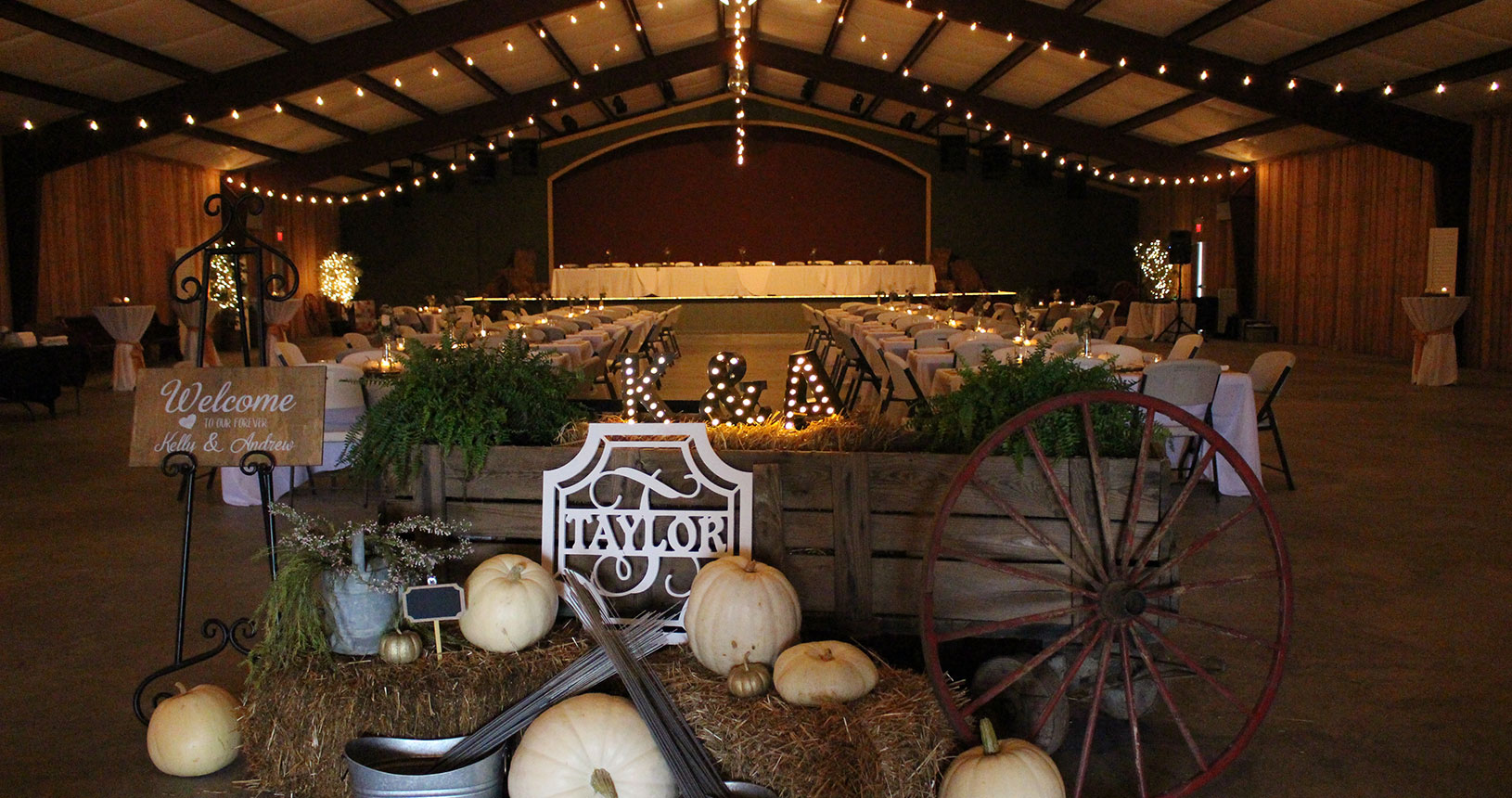 A barn with hay and pumpkins for sale.
